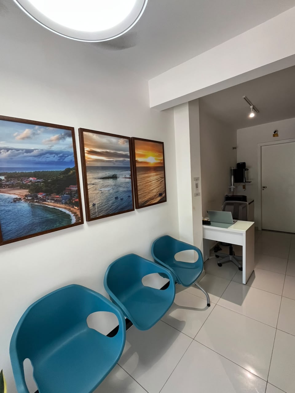 Sala de espera da Plusdent com quadros do litoral baiano